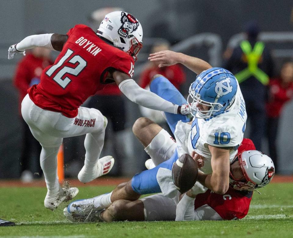 North Carolina quarterback Drake Maye (10) fumbles the ball in the first quarter after a hit by N.C. State linebacker Payton Wilson (11) on Saturday, November 25, 2023 at Carter-Finley Stadium in Raleigh, N.C.