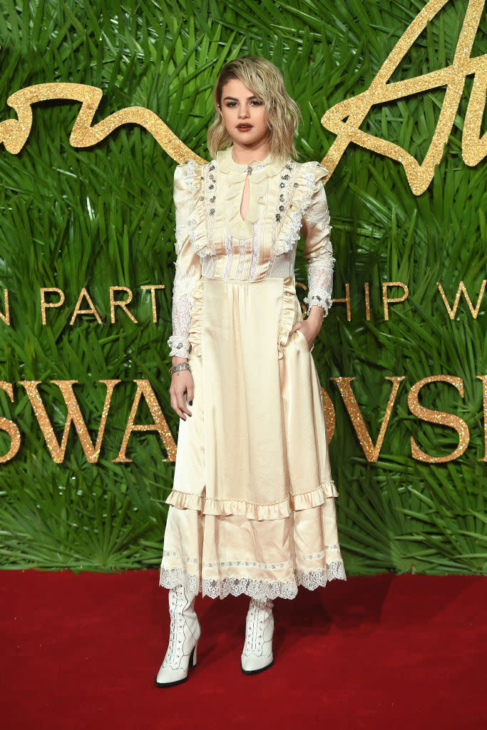 <p>Selena Gomez made her ruffle dress seem a little less sweet with edgy white boots and a dark lip. (Photo: Getty Images) </p>