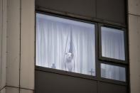 A dog looks out of a window in the Burnham Tower residential block, as residents were evacuated as a precautionary measure following concerns over the type of cladding used on the outside of the buildings on the Chalcots Estate in north London, Britain, June 24, 2017. REUTERS/Hannah McKay