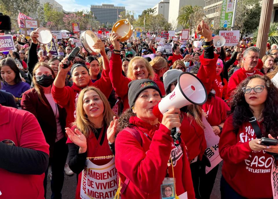 A crowd of people dressed mostly in red gather for a rally.