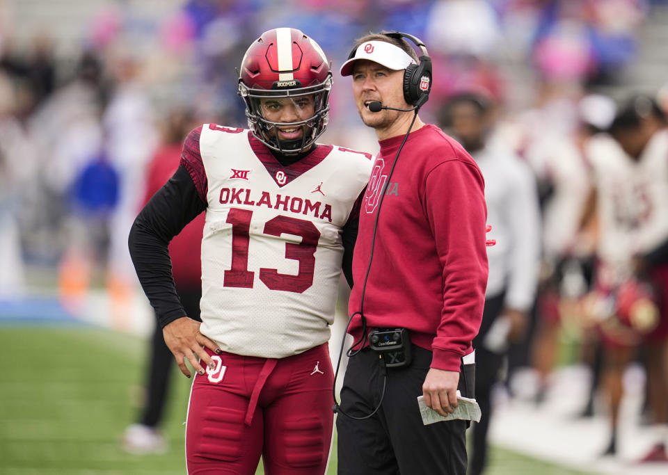 Oct 23, 2021; Lawrence, Kansas, USA; Oklahoma Sooners quarterback Caleb Williams (13) talks with head coach Lincoln Riley during the second half against the Kansas Jayhawks at David Booth Kansas Memorial Stadium. Mandatory Credit: Jay Biggerstaff-USA TODAY Sports