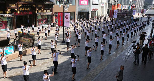 Nearly ten thousand shop assistants dance gymnastic exercise to attract customers in China. Source: Getty