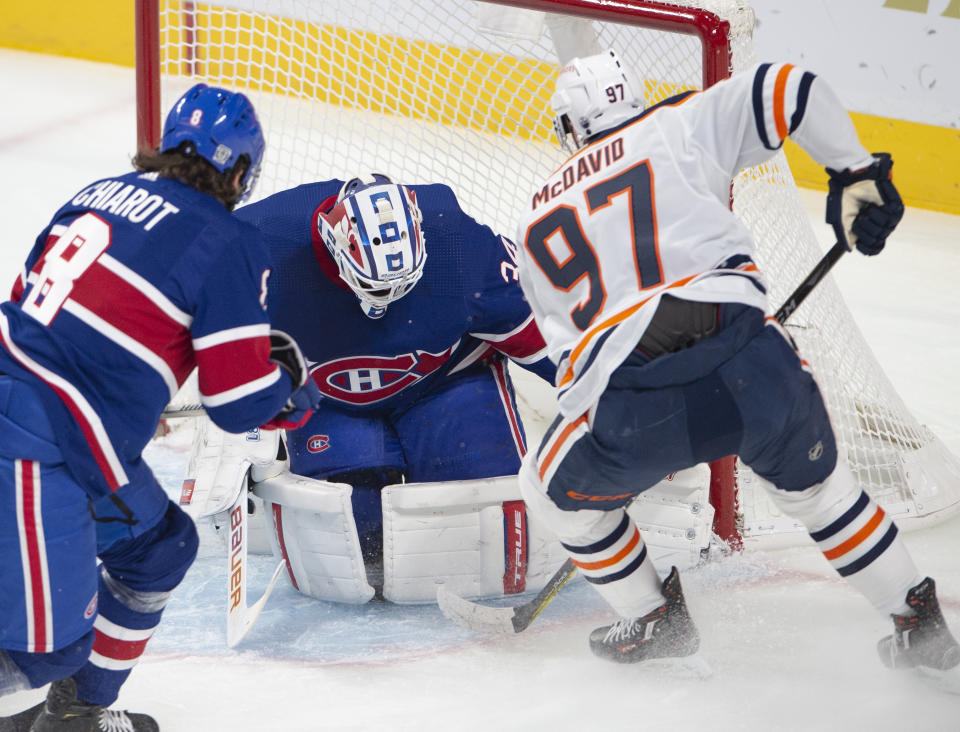 Montreal Canadiens goaltender Jake Allen (34) stops Edmonton Oilers center Connor McDavid (97) as Canadiens defenseman Ben Chiarot (8) moves in during first-period NHL hockey game action in Montreal, Thursday, Feb. 11, 2021. (Ryan Remiorz/The Canadian Press via AP)