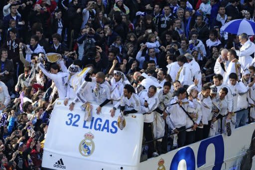 Real Madrid's players arrive on an open bus at Cibeles square in Madrid. Thousands of jubilant Real Madrid fans swamped the centre of the Spanish capital on Thursday to see their heroes parade in an open-top bus in celebration of their league title success