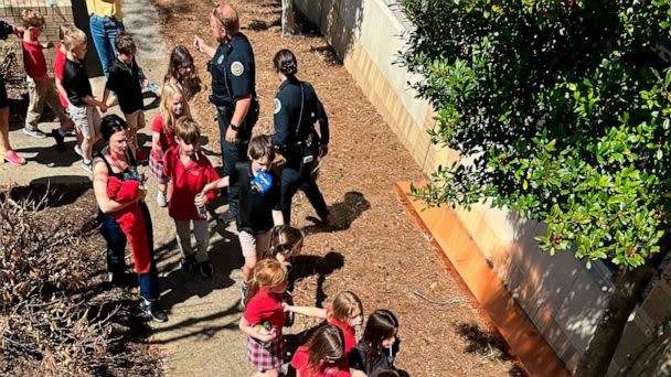 PHOTO: Children from The Covenant School, a private Christian school in Nashville, Tenn., hold hands as they are taken to a reunification site at the Woodmont Baptist Church after a shooting at their school, Mar. 27, 2023. (George Uribe/AP)