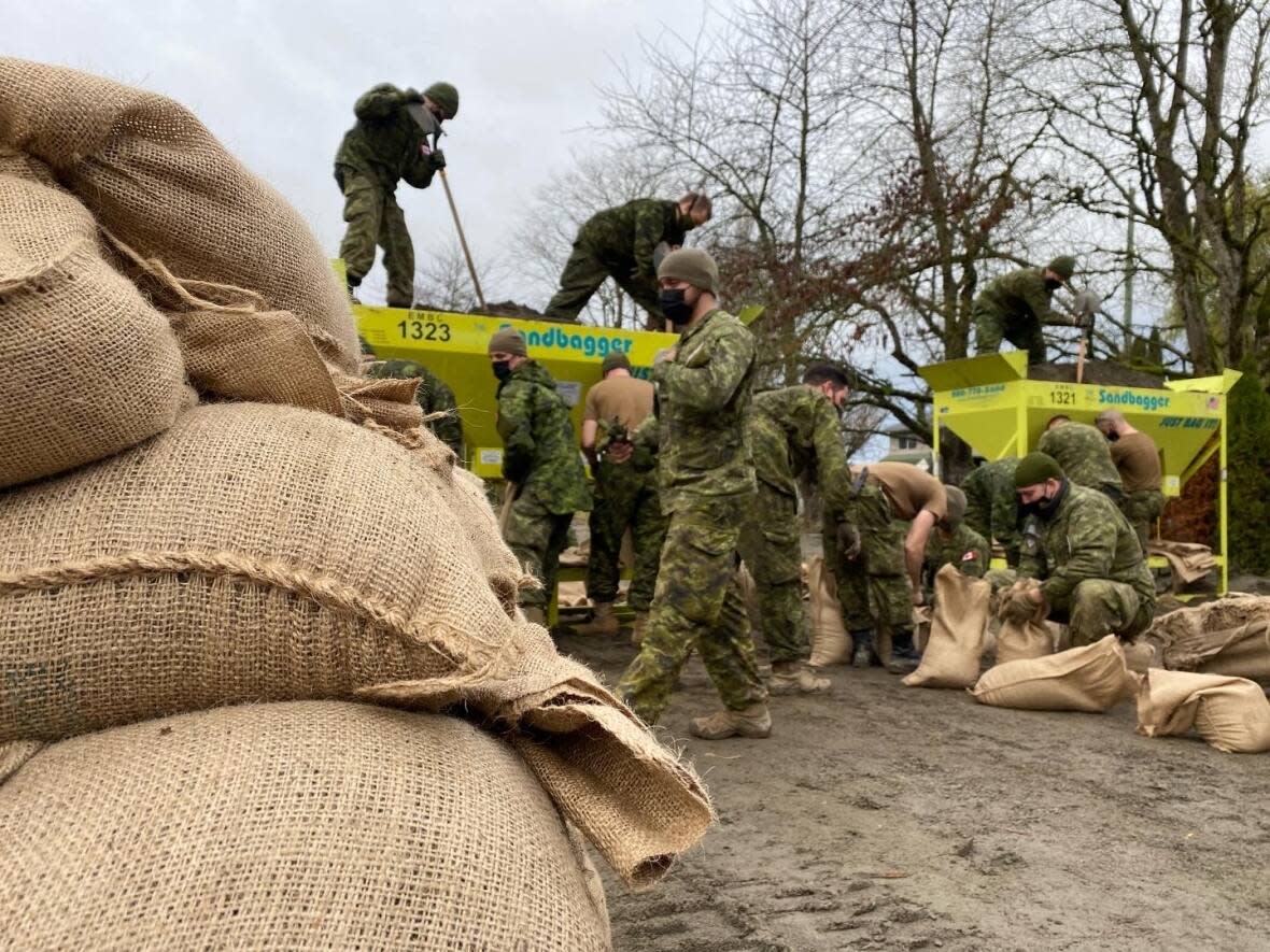 Soldiers work on flood recovery in Abbotsford, B.C., on Wednesday just one day before the first in a series of three more storms are expected to bring excessive rainfall to the region.  (David Common/CBC - image credit)