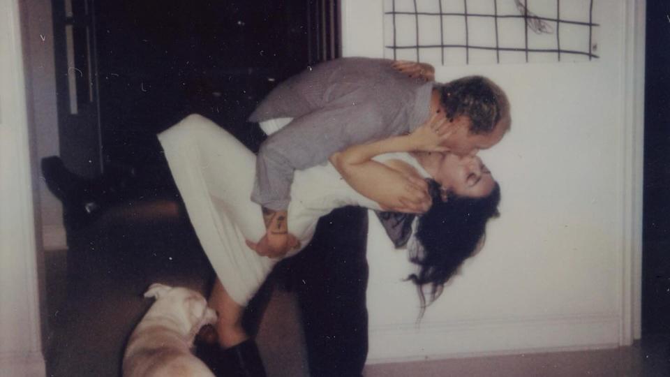 Charli and George kissing with a dog watching 