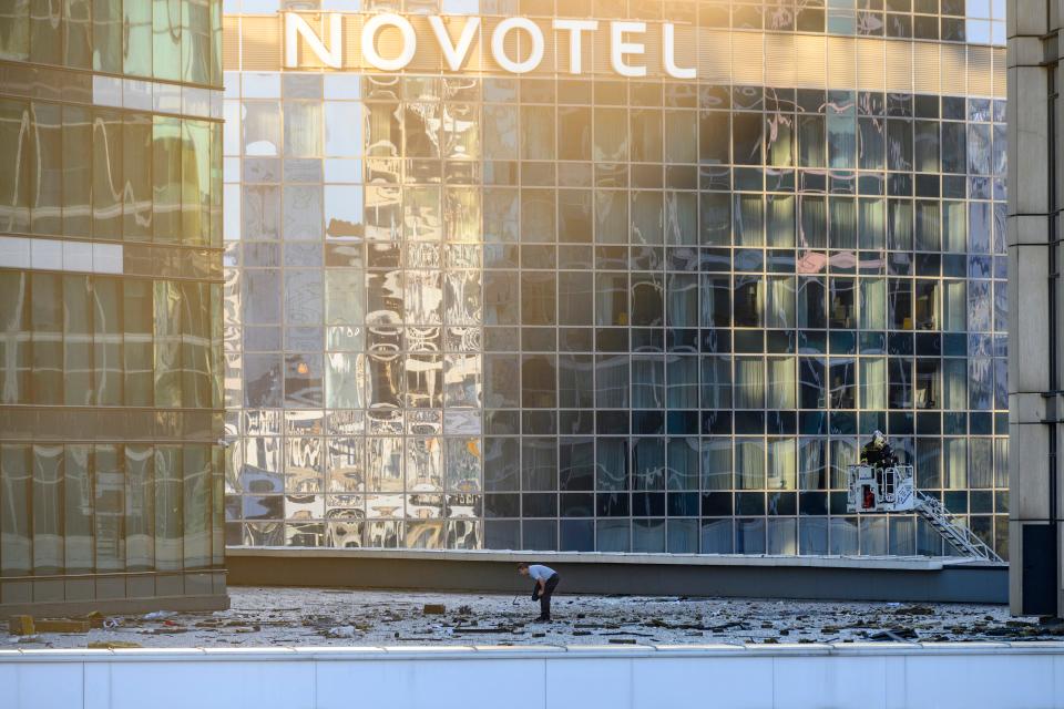 Investigators examine an area next to damaged building in the "Moscow City" business district after a reported drone attack in Moscow, Russia, on Aug. 1, 2023.