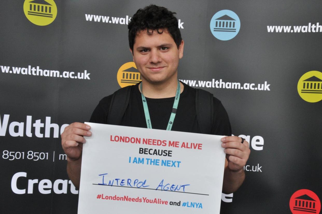 Warning: student Felippe Saraiva holds up placard for the Mayor's anti-knife campaign, to show how killings snuff out promising future careers