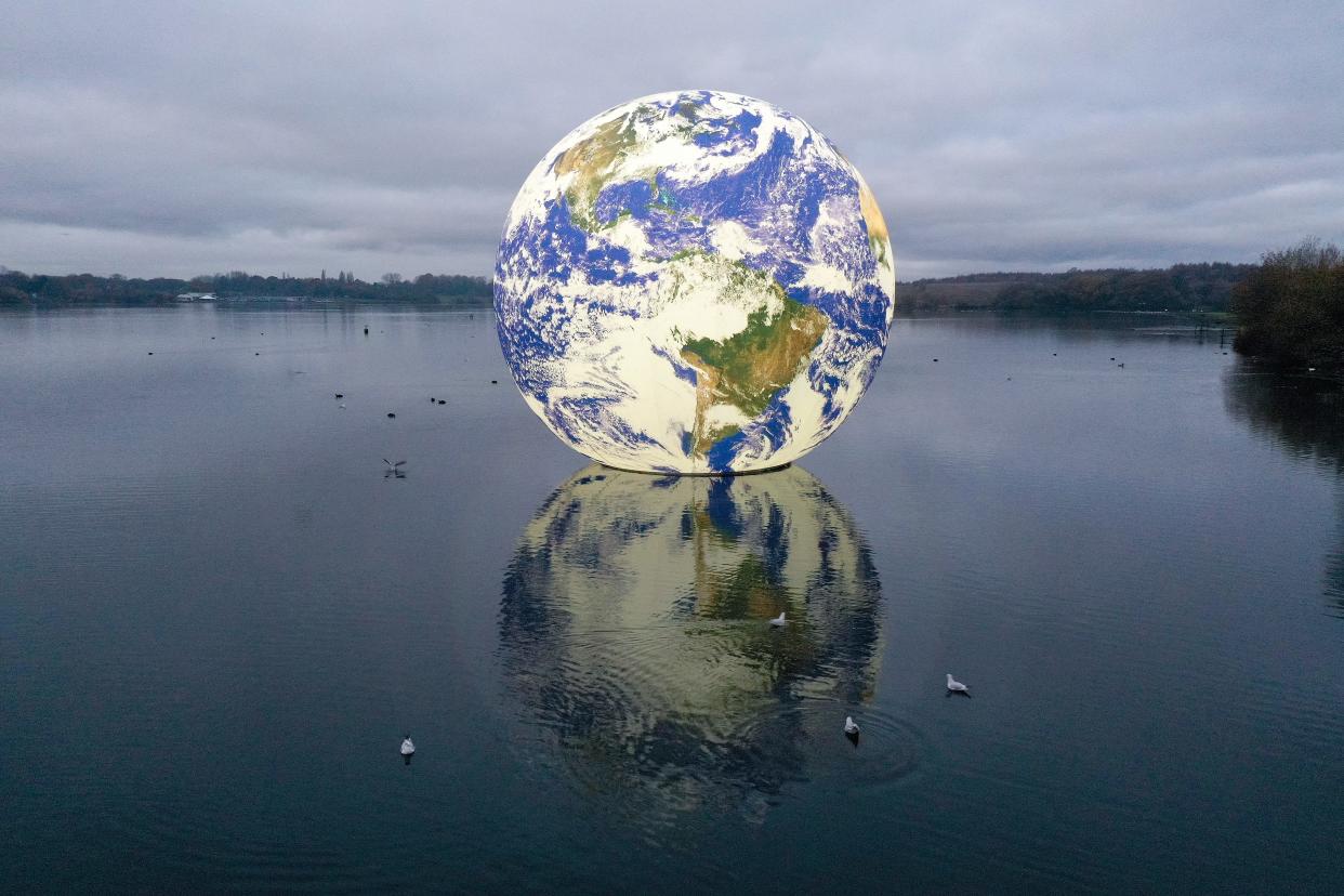 November 23, 2021: Luke Jerram's 'Floating Earth' is seen at Pennington Flash in Wigan, England. The floating Earth will hover over Pennington Flash for 10 days from November 19, as part of a celebration of Wigan and Leigh's watercourses and is the first time one of Jerram's globes has been floated on an open expanse of water.