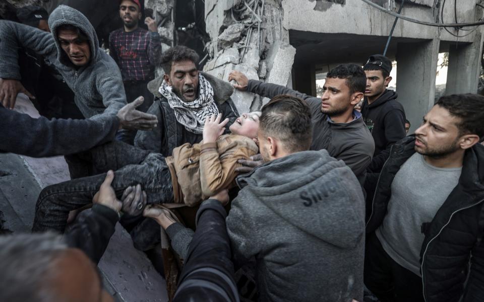 A child is pulled out from rubble after Israeli attacks on the house belonging to the al-Wawawi family