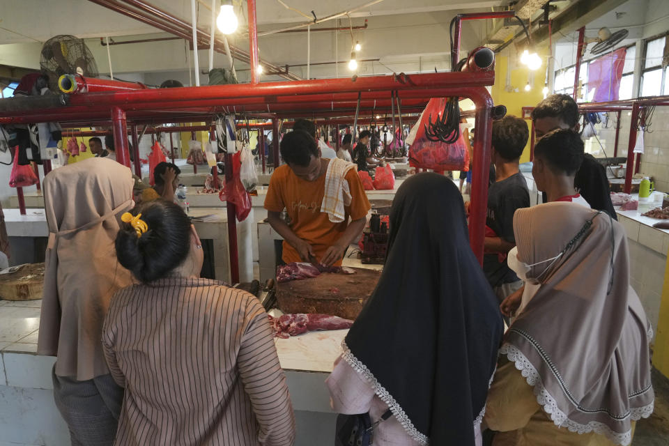 A butcher, center, serves customers at a market in Jakarta, Indonesia, Wednesday, March 22, 2023. Millions of Muslims in Indonesia are preparing to welcome the holy month of Ramadan, which is expected to start on Thursday, with traditions and ceremonies in the world's largest Muslim-majority country amid soaring food prices. (AP Photo/ Ahmad Ibrahim)