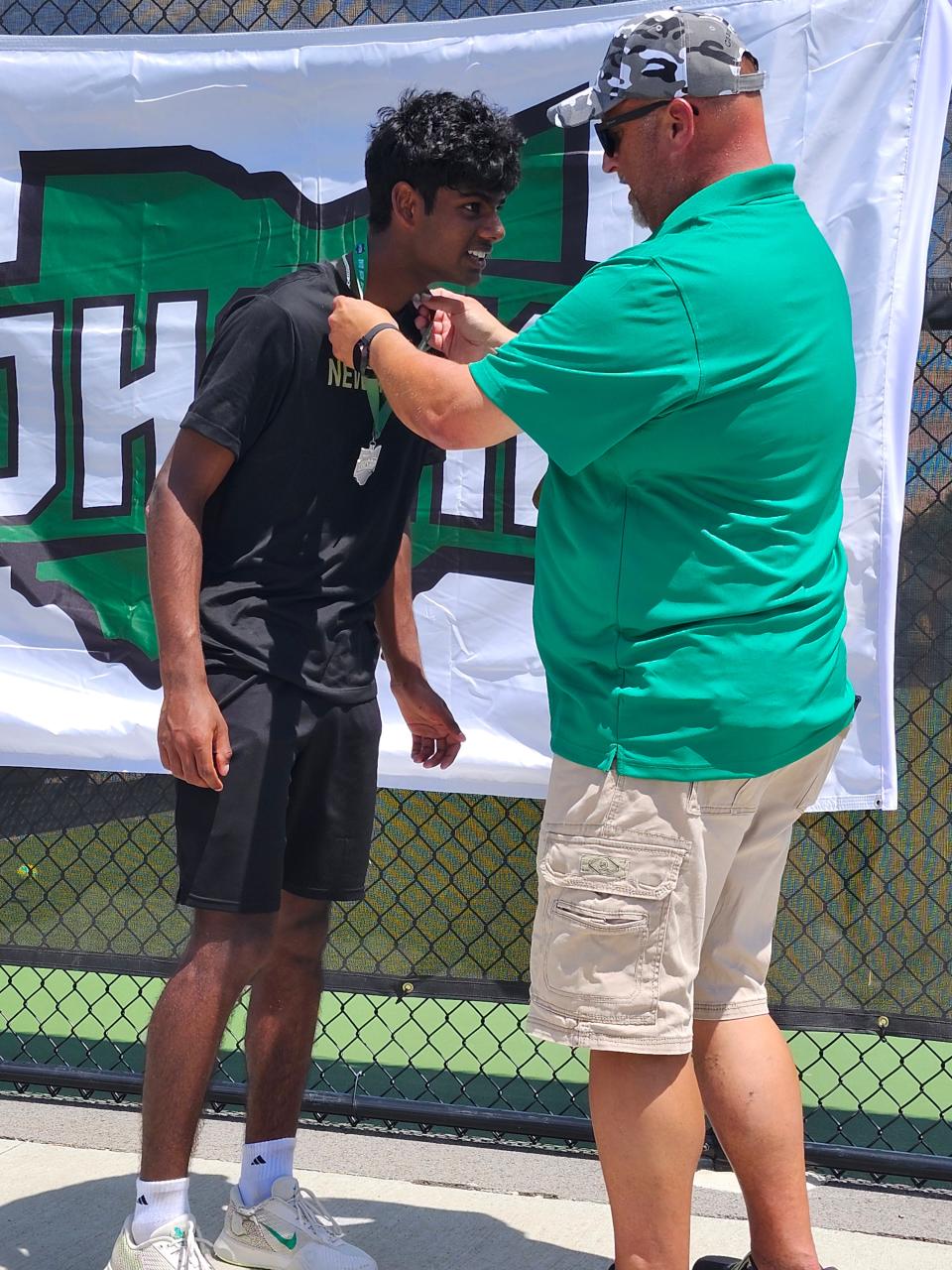 Abhinav Dandu, de New Albany, izquierda, recibe la medalla de subcampeón estatal de individuales de la División I de manos del entrenador de Centerville, Scott Long, el viernes en el College of Wooster. Dandu, un junior, perdió 6-2, 6-2 ante Carson Dwyer de Cincinnati St. Xavier.