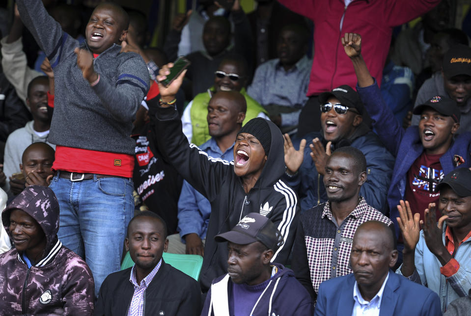 Kenyans celebrate Eliud Kipchoge's sub-2 hour marathon time, outside the Kenya International Conference Center in downtown Nairobi, Kenya Saturday, Oct. 12, 2019. Eliud Kipchoge has become the first athlete to run a marathon in less than two hours, at an event set up for the attempt in Austria, although it will not count as a world record. (AP Photo/John Muchucha)