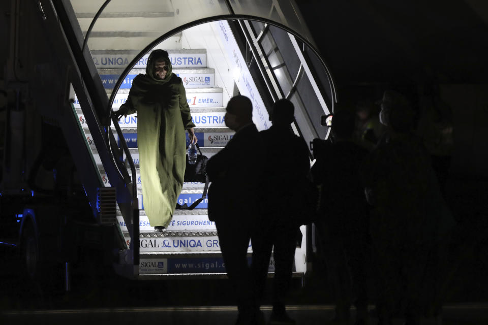An evacuated citizen from Afghanistan arrives at Tirana International Airport in Tirana, Albania, Friday, Aug. 27, 2021. A government decision has planned that the Afghans may stay at least a year during which they will proceed with their application for special visas before they move on to the U.S. for final settlement. (AP Photo/Franc Zhurda)