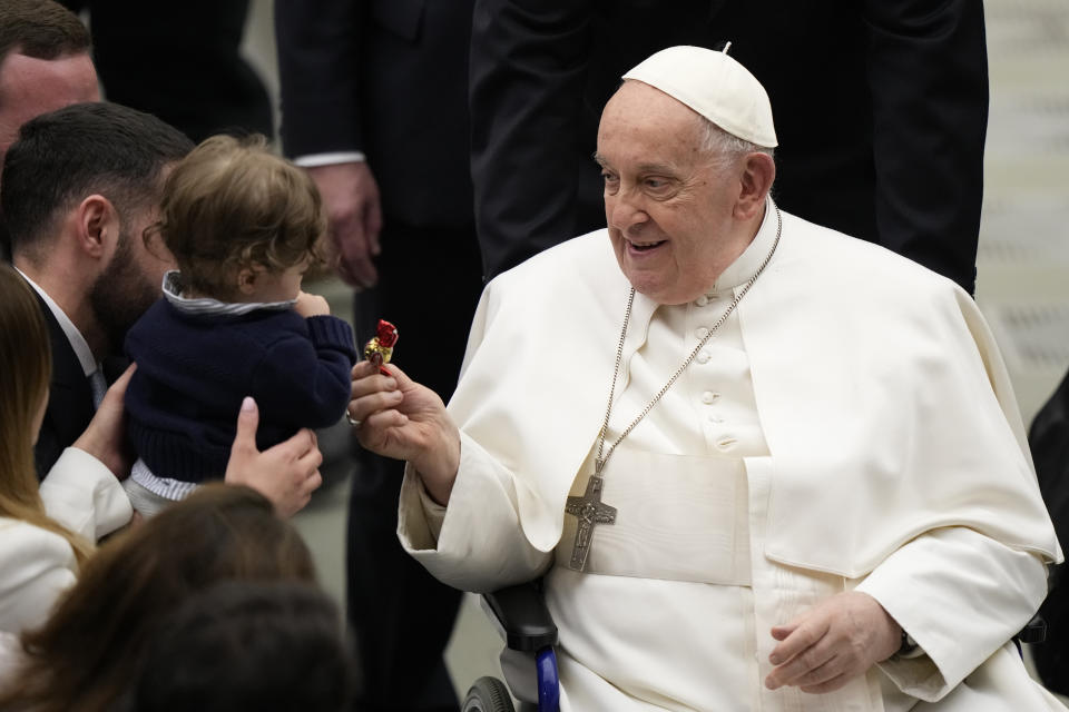 Pope Francis gives a candy to a baby at the end of his weekly general audience in the Paul VI Hall, at the Vatican, Wednesday, Feb. 28, 2024. (AP Photo/Andrew Medichini)