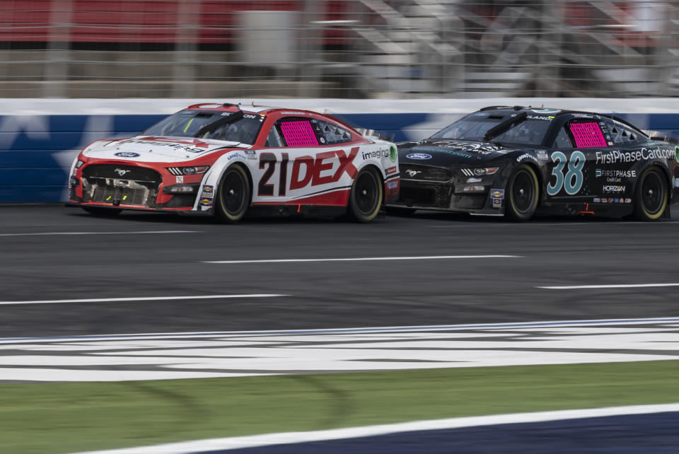 Harrison Burton (21) and Todd Gilliland (38) compete during a NASCAR Cup Series auto race at Charlotte Motor Speedway, Sunday, Oct. 9, 2022, in Concord, N.C. (AP Photo/Matt Kelley)