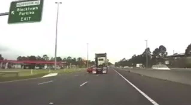The sedan spins out to the front of the truck and is pushed sideways along the motorway. Pictures: Dash Cam Owners Australia/Facebook