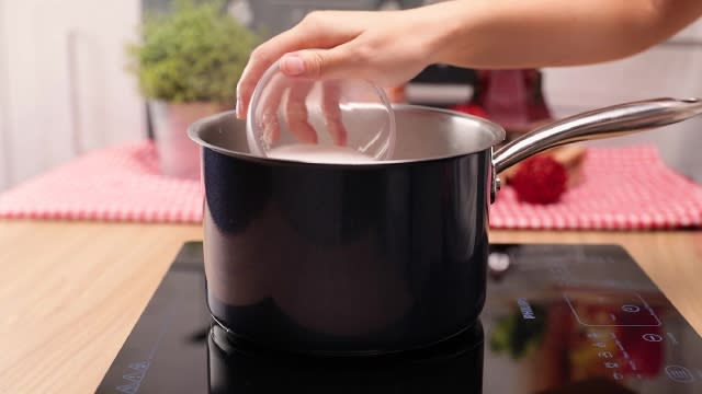 Adding sugar to a metal pot on heat