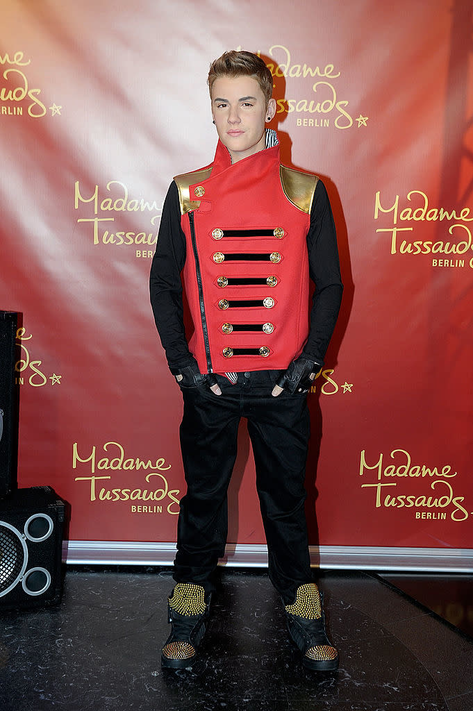 Wax figure of Justin Bieber in a red and black military-style jacket and black pants at Madame Tussauds