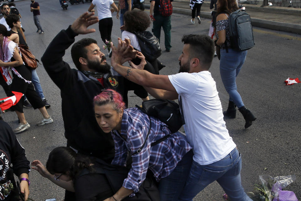 FILE - In this Oct. 29, 2019 file photo, a Hezbollah supporter, right, clashes with an anti-government protester, left, during a protest in Beirut, Lebanon. Iranian-backed Hezbollah built a reputation among supporters in Lebanon as a champion of the poor and a defender of the country against Israel's much more powerful military. Lebanon’s protests have shown unusual overt anger at the country’s powerhouse, Hezbollah. (AP Photo/Bilal Hussein, File)