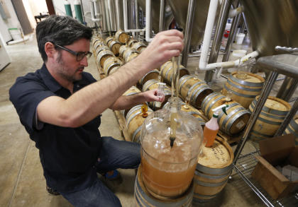 Co-Owner of Ardent Craft Ales, Kevin O'Leary, takes a sample of Persimmon beer at the facility in Richmond, VA., Tuesday, Dec. 2, 2014. Ardent Craft Ales is tapping into the Virginia Historical Society’s collections to serve up a 300-year-old beer made with persimmons from a cookbook from the 1700s. The beer recipe is one of several in the society’s collection that provide a glimpse into what Virginians and others were drinking in the 18th century. (AP Photo/Steve Helber)