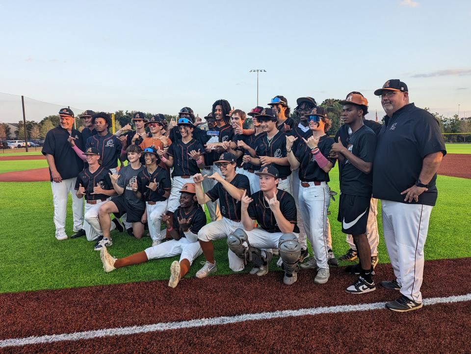 Atlantic Coast players and coaches celebrate with the trophy after defeating Englewood for the Gateway Conference baseball championship on April 19, 2024. [Clayton Freeman/Florida Times-Union]