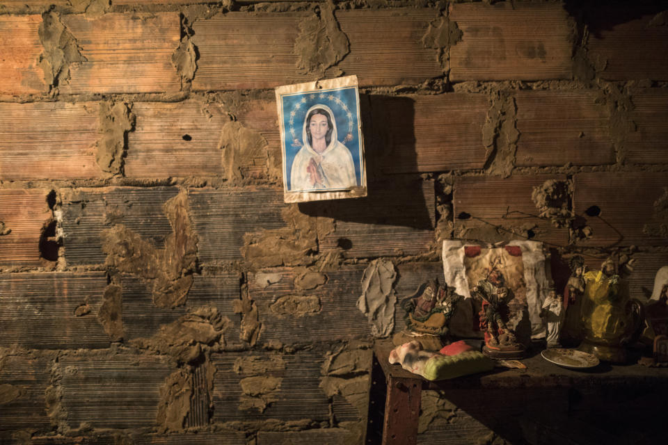 An image of the Virgin Mary hangs from a brick wall next to the room where the corpse of Teresa Jimenez is prepared following her death from natural causes at the age of 91 in Maracaibo, Venezuela, Nov. 17, 2019. The cost of transporting a body, buying a casket and burial plot for a funeral can run into the hundreds of dollars, or more, while most earn the minimum wage of roughly $3 a month as hyperinflation devours pay. (AP Photo/Rodrigo Abd)
