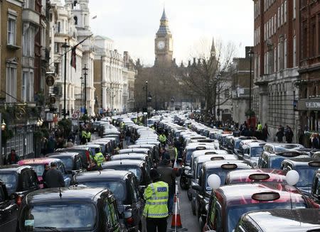 A police officer stands between rows of taxis during a protest by London cab drivers against Uber in central London, February 10, 2015 REUTERS/Stefan Wermuth