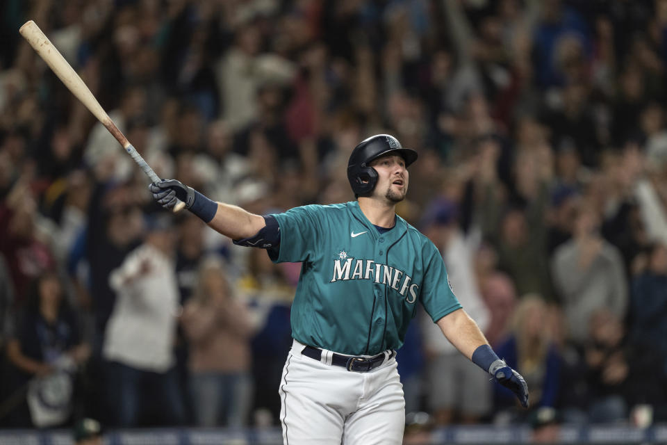 Seattle Mariners' Cal Raleigh watches his solo home run off Oakland Athletics relief pitcher Domingo Acevedo during the ninth inning of a baseball game Friday, Sept. 30, 2022, in Seattle. The Mariners won 2-1 to clinch a spot in the playoffs. (AP Photo/Stephen Brashear)