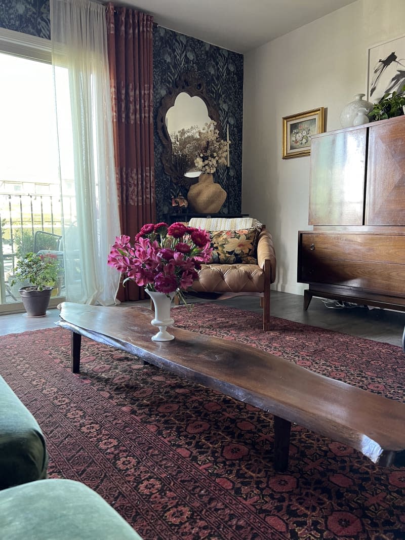Living room with lots of floral patterns via wallpaper, rug, textiles