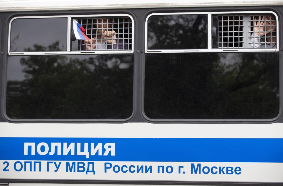 Detained protesters look out of a police bus window during a march in Moscow, Russia, Wednesday, June 12, 2019. Police and hundreds of demonstrators are facing off in central Moscow at an unauthorized march against police abuse in the wake of the high-profile detention of a Russian journalist. More than 20 demonstrators have been detained, according to monitoring group. (AP Photo/Alexander Zemlianichenko)