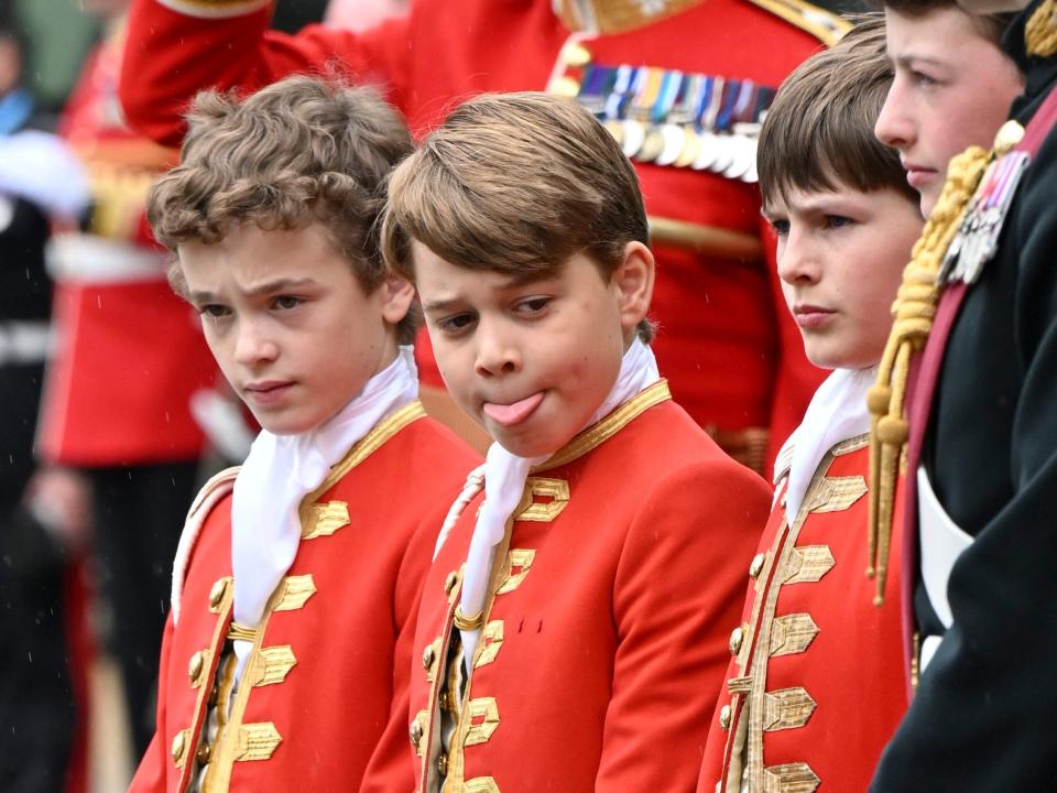 Prince George (center) is dressed in a red suit as a page of honor at the coronation of King Charles III and Queen Camilla at Westminster Abbey on May 6, 2023, in London, England.