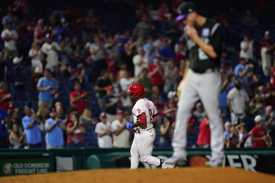 Philadelphia Phillies' Jean Segura, left, rounds the bases past Colorado Rockies pitcher Kyle Freeland after hitting a home run during the fifth inning of a baseball game, Saturday, Sept. 11, 2021, in Philadelphia. (AP Photo/Matt Slocum)