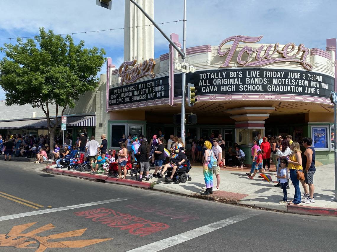 Parade-goers find spots on the Olive Avenue sidewalk in front of the Tower Theatre to watch the 2022 Fresno Pride Parade on Saturday, June 4.