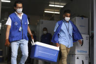 Health Ministry workers carry coolers of COVID-19 vaccines that El Salvador's government is donating to Honduras as they load trucks that will depart San Salvador, El Salvador, Thursday, May 13, 2021. (AP Photo/Salvador Melendez)