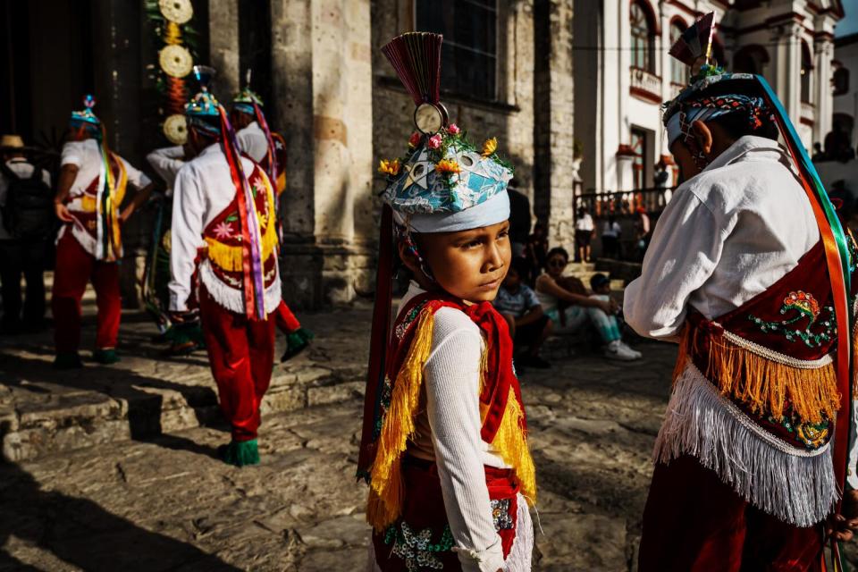 Voladores dance in a line as the procession heads into church before climbing up to fly,