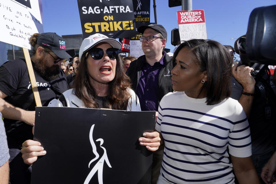 SAG-AFTRA president Fran Drescher, left, takes part in a rally by striking writers and actors outside Netflix studio in Los Angeles on Friday, July 14, 2023. This marks the first day actors formally joined the picket lines, more than two months after screenwriters began striking in their bid to get better pay and working conditions. (AP Photo/Chris Pizzello)