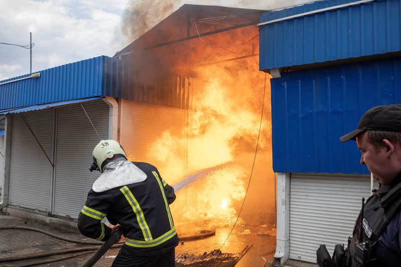 Bomberos rocían agua sobre el fuego en el mercado tras los bombardeos, mientras continúa el ataque de Rusia a Ucrania, en Sloviansk, región de Donetsk, Ucrania