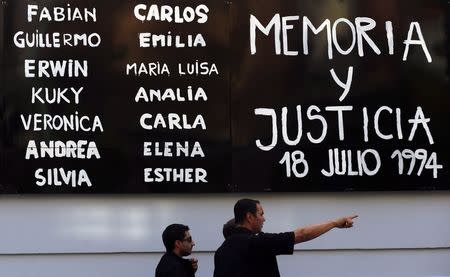 Pedestrians walk by a sign that reads "Memory and Justice" next to the names of the victims of the 1994 Amia bombing, placed outside the AMIA Jewish community center before a demonstration to demand justice over the death of Argentine prosecutor Alberto Nisman in Buenos Aires January 21, 2015. REUTERS/Marcos Brindicci