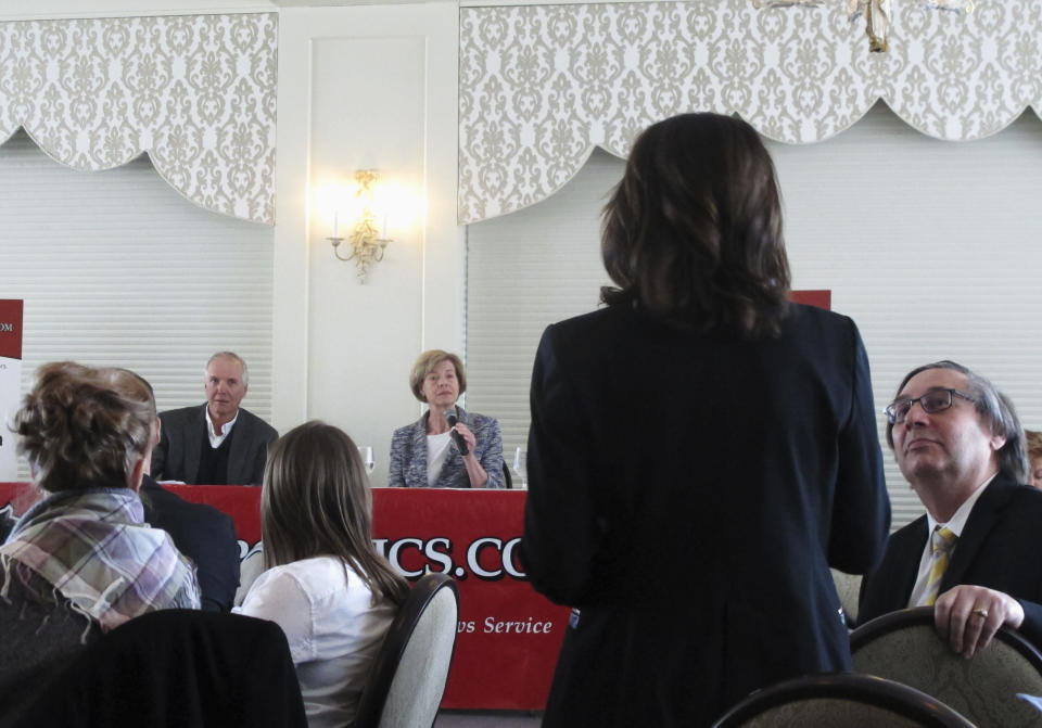 FILE - In this Feb. 22, 2018, file photo, Republican Senate candidate Leah Vukmir, standing, asks a question of Democratic U.S. Sen. Tammy Baldwin during a luncheon in Madison, Wis. Vukmir faces Baldwin in one of the most expensive Senate races in the country. (AP Photo/Scott Bauer, File)