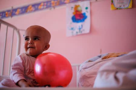 A child plays with a balloon inside the cancer ward at The Children's Hospital in Damascus, Syria February 20, 2017. Picture taken February 20, 2017. REUTERS/Omar Sanadiki