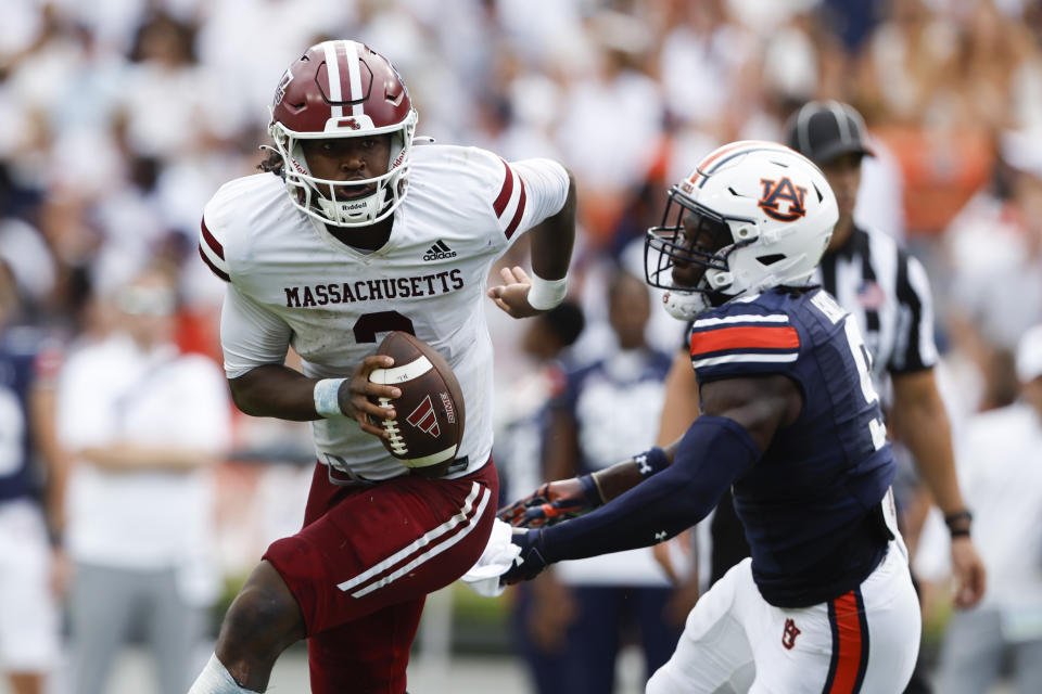 Massachusetts quarterback Taisun Phommachanh (3) eludes the pursuit of Auburn linebacker Eugene Asante (9) as he scrambles for yardage during the first half of an NCAA college football game Saturday, Sept. 2, 2023, in Auburn, Ala. (AP Photo/Butch Dill)