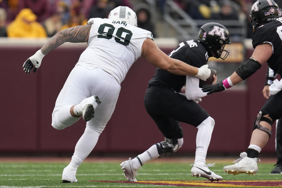 Minnesota quarterback Athan Kaliakmanis (8) is sacked by Michigan State defensive lineman Jalen Sami (99) during the first half of an NCAA college football game Saturday, Oct. 28, 2023, in Minneapolis. (AP Photo/Abbie Parr)