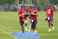 Minnesota Vikings quarterbacks Nate Stanley, right, and Jake Browning, center, watch Kirk Cousins hop-step through a drill during the NFL football team's training camp, Thursday, Aug. 5, 2021, in Eagan, Minn. (AP Photo/Jim Mone)