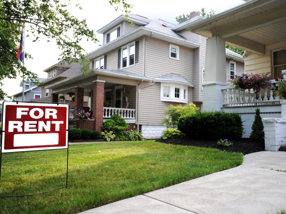 A for-rent sign in front of a suburban house in the US