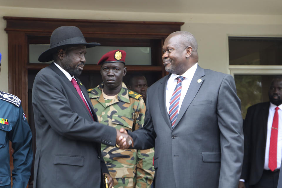 South Sudan's President Salva Kiir left, and opposition leader Riek Machar, right, shake hands after meetings Sunday Oct. 20, 2019, to discuss outstanding issues to the peace deal. Machar made an impassioned plea to a visiting United Nations Security Council delegation that met with him and President Salva Kiir, to urge speedier progress in pulling the country out of a five-year civil war. (AP Photo/Sam Mednick)