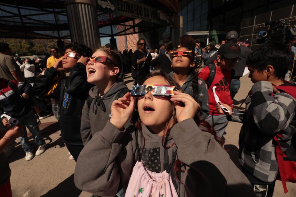 Students in protective eyewear were part of the crowd that gathered at the California Science Center to look up at the sky.