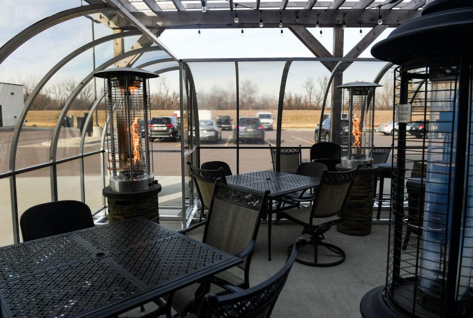 Plexiglass walls are placed around the outdoor patio on Thursday, December 10, at JJ's Wine, Spirits and Cigars on 57th Street in Sioux Falls.