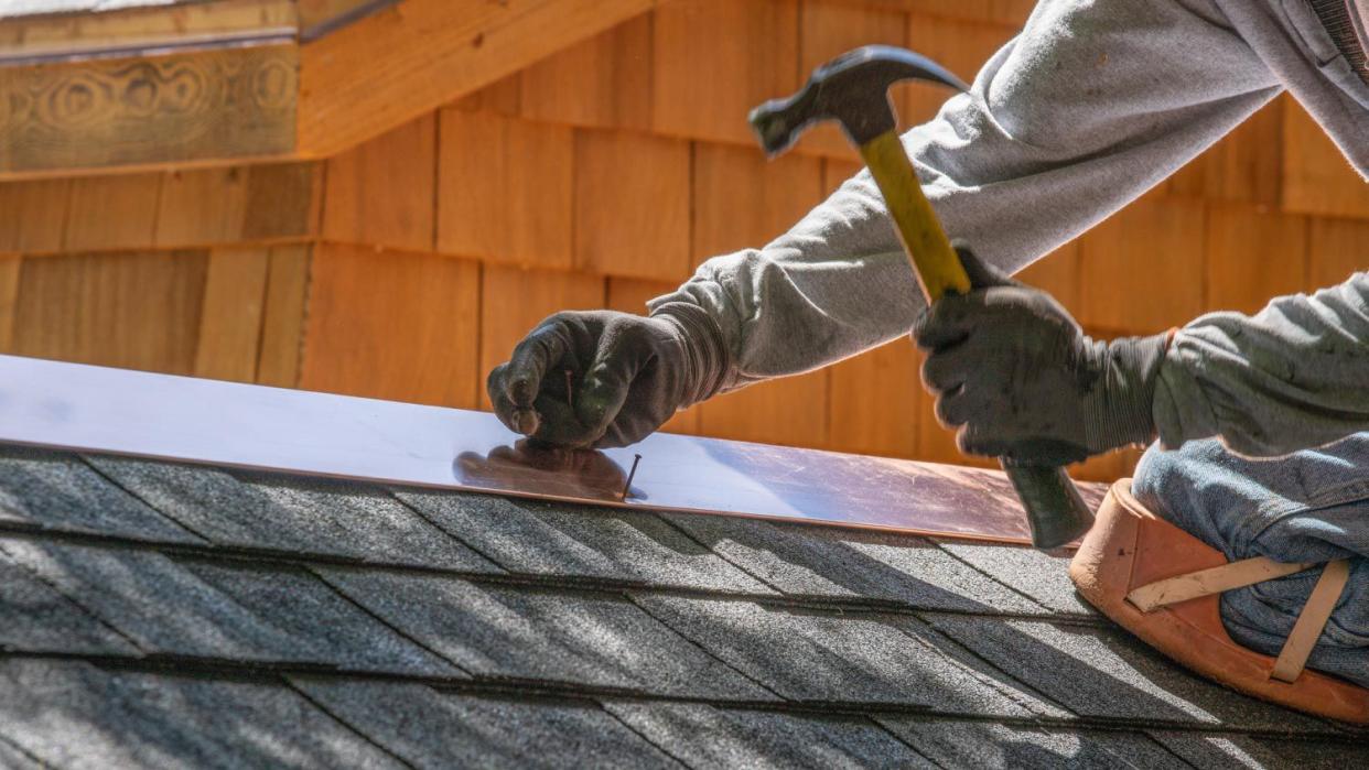 Man installing asphalt roof